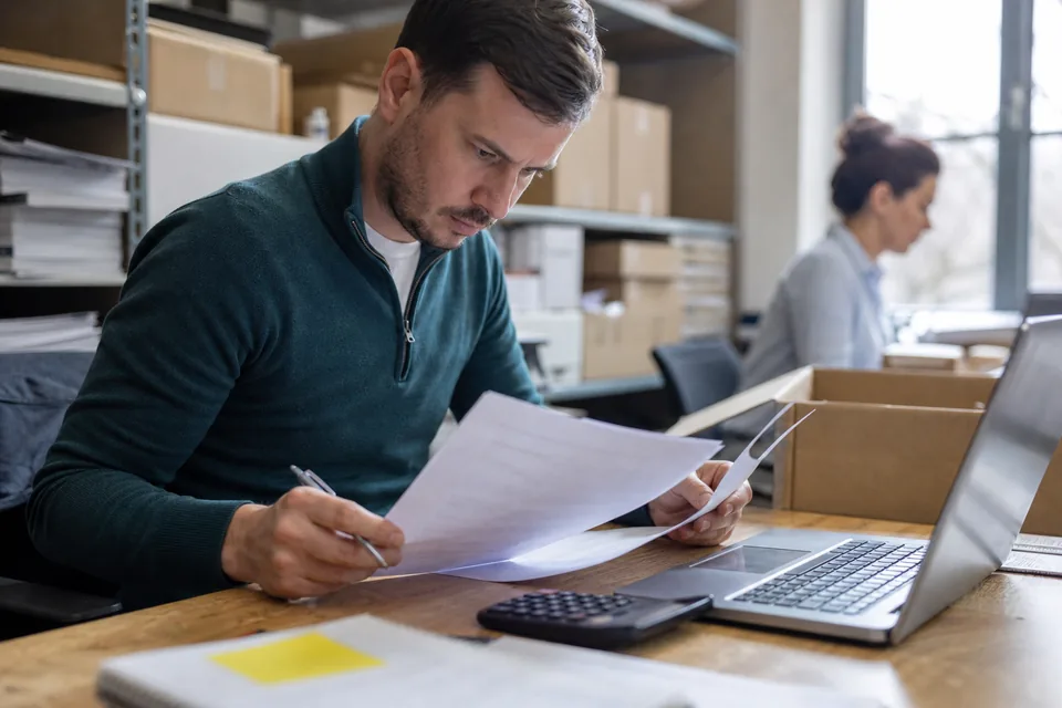Operations manager comparing software subscription invoices at a desk