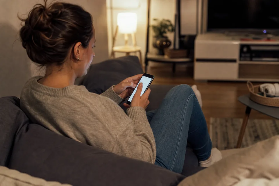 Patient booking a dental cleaning from her phone at home in the evening