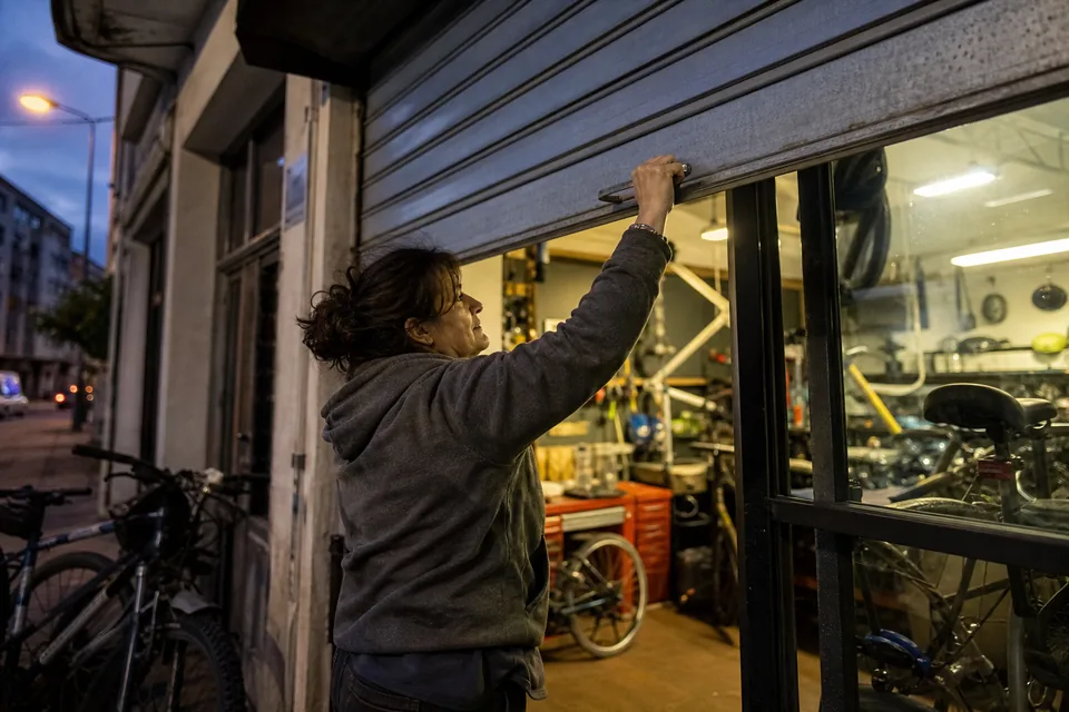 Shop owner locking the door in the evening while the website keeps answering customers